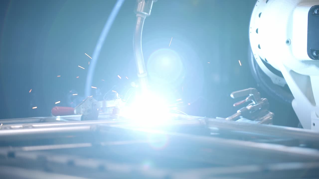 강철 프레임에 용접을 만드는 로봇 용접기의 슬로우 모션 영상을 닫습니다.