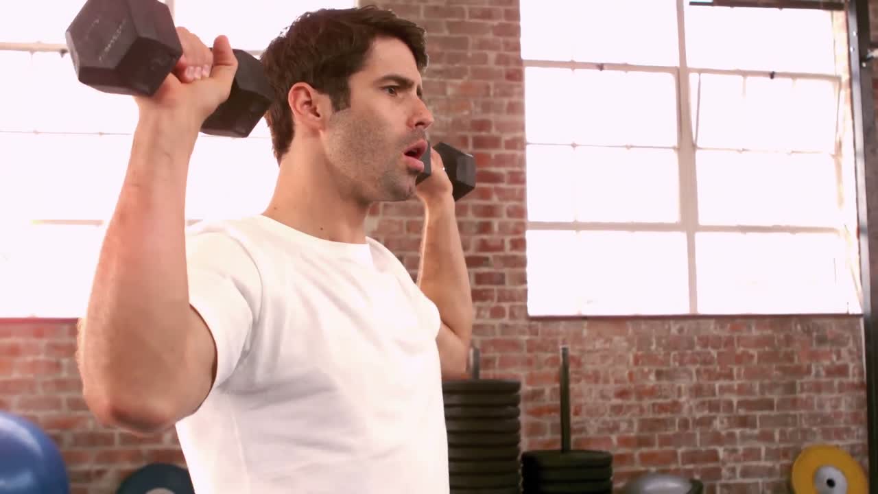 무거운 검은색 덤벨을 들어 올리는  ⁇ 한 남자