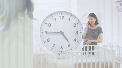 휴대 전화 에 대화 하는 침대 에 앉아 있는 행복 한 임신 한 아시아 여자 를 가리키는 시계