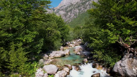 flying low over a mountain river in valley of valbona, famous destination for tourists in albania