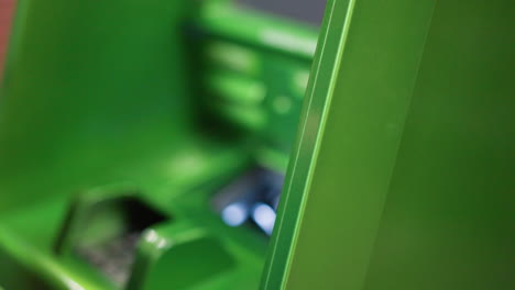 view of a hand wearing beaded bracelets and a black shirt collecting money from a green atm machine. shot with a handheld camera, capturing the moment of withdrawing cash from an atm