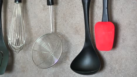 kitchen utensils hanging on gray background