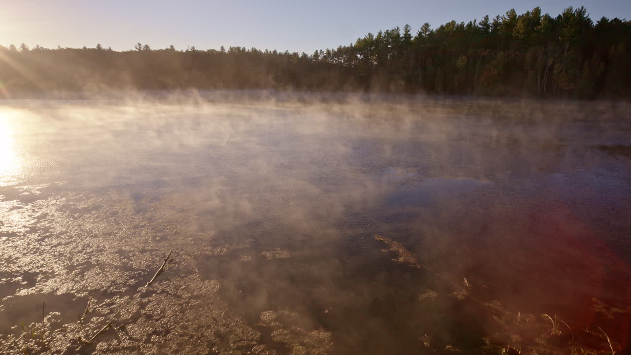 Drone view of rising morning haze over still water