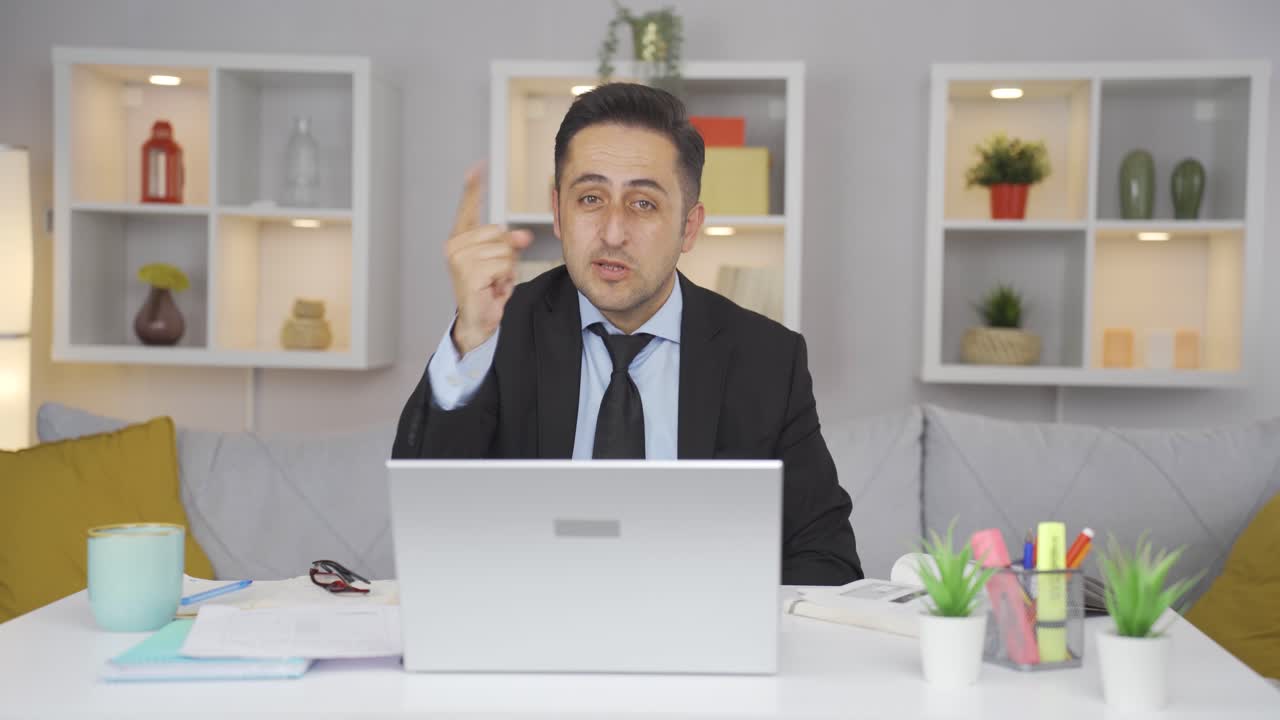 홈 오피스 워커 남자가 카메라에 동기를 부여하고 있습니다.