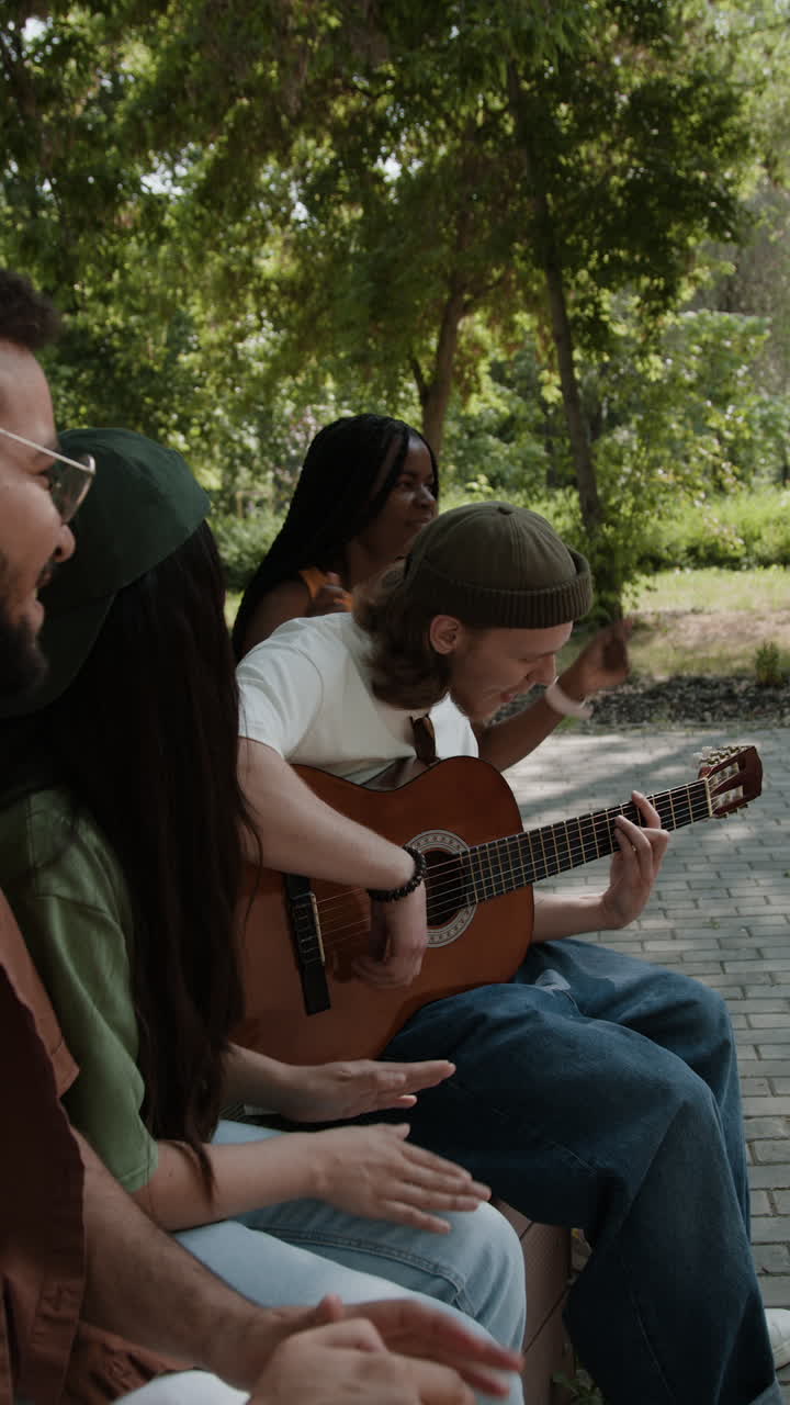 Friends Playing Acoustic Guitar in a Park