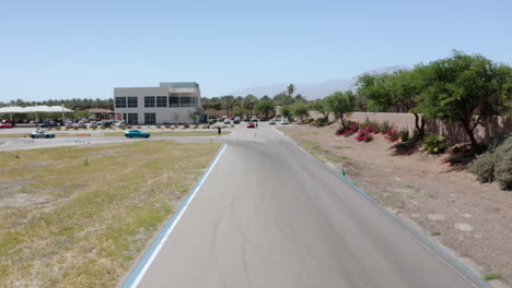 Drone-captures-an-aerial-shot-of-a-car-driving-on-a-road-in-Palm-Springs,-California,-near-Los-Angeles