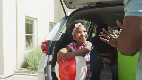 Glückliche-Afroamerikanische-Familie-Packt-Auto-Mit-Wasserbällen-Im-Urlaub