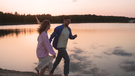 una pareja joven a la orilla del lago.