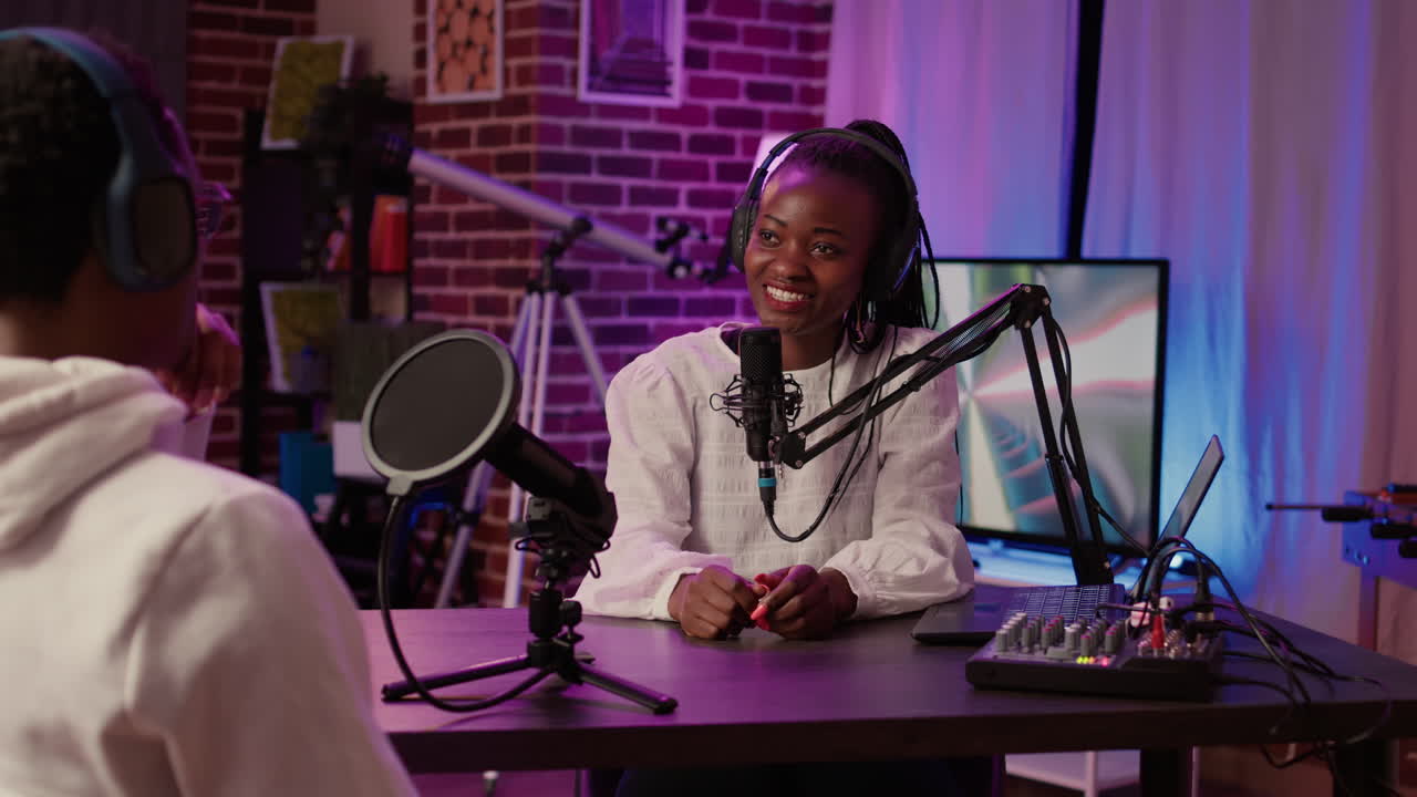 African american couple recording vlog using digital camera while recording podcast using professional microphone