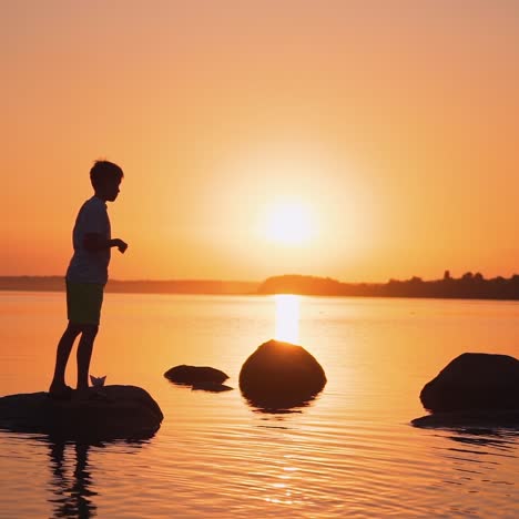 little boy with paper plane. beautiful sunset. origami.