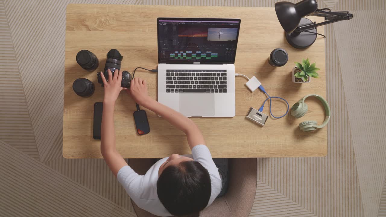 mujer trabajando desde casa en una computadora portátil editando fotos y videos