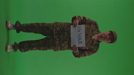 full body of asian male soldier holding white paper with slogan no war while standing on the green screen background