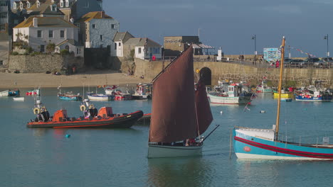 barco de vela tradicional de cornualles con vela roja en el puerto de st