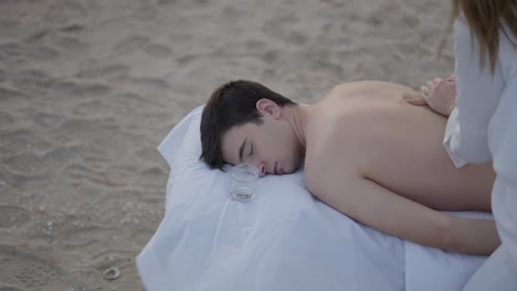 man receiving a beach massage