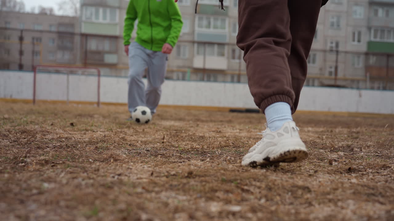 Partido de fútbol intenso y embarrado, jugadores chocando con fuerza en un campo mojado, la rivalidad se intensifica con un duelo de fútbol enérgico y embarrado, primer plano de un duelo atlético con regates rápidos y entradas duras en un entorno embarrado.