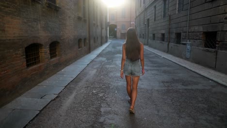 woman walking down a narrow city alley