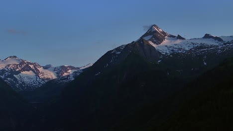 Mountain-range-in-shadow-with-peaks-in-snow-and-rock