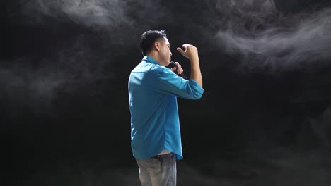 hombre cantando con micrófono en el escenario