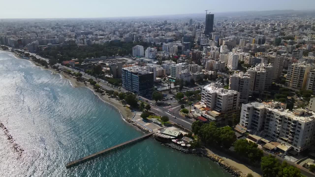 Aerial view of Durrës, Albania—coastal high-rise towers above mid-rise blocks and green urban sprawl. The scene captures architectural contrast, city planning, and seaside proximity
