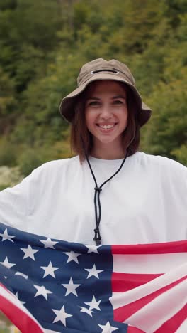 woman holding american flag in forest