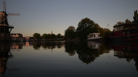 Windmill-De-Adriaan-along-the-Spaarne-river-in-Haarlem-city-centre-at-dawn-with-calm-waters