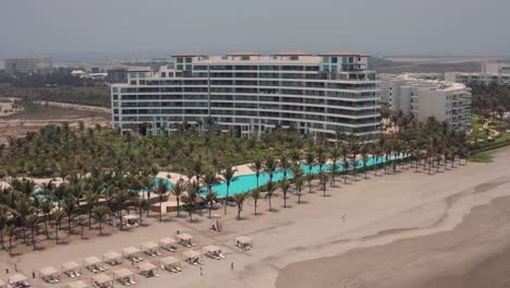 Aerial-View-on-Upscale-Condo-Buildings-and-Pools-By-Tropical-Beach-in-Acapulco,-Mexico