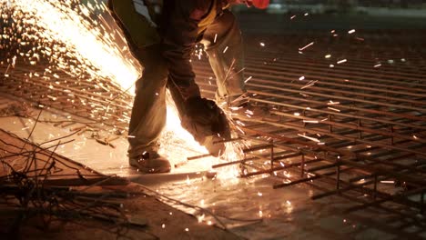 industrial professional worker is cutting metal rebar with a circular saw. construction of a factory, hangar