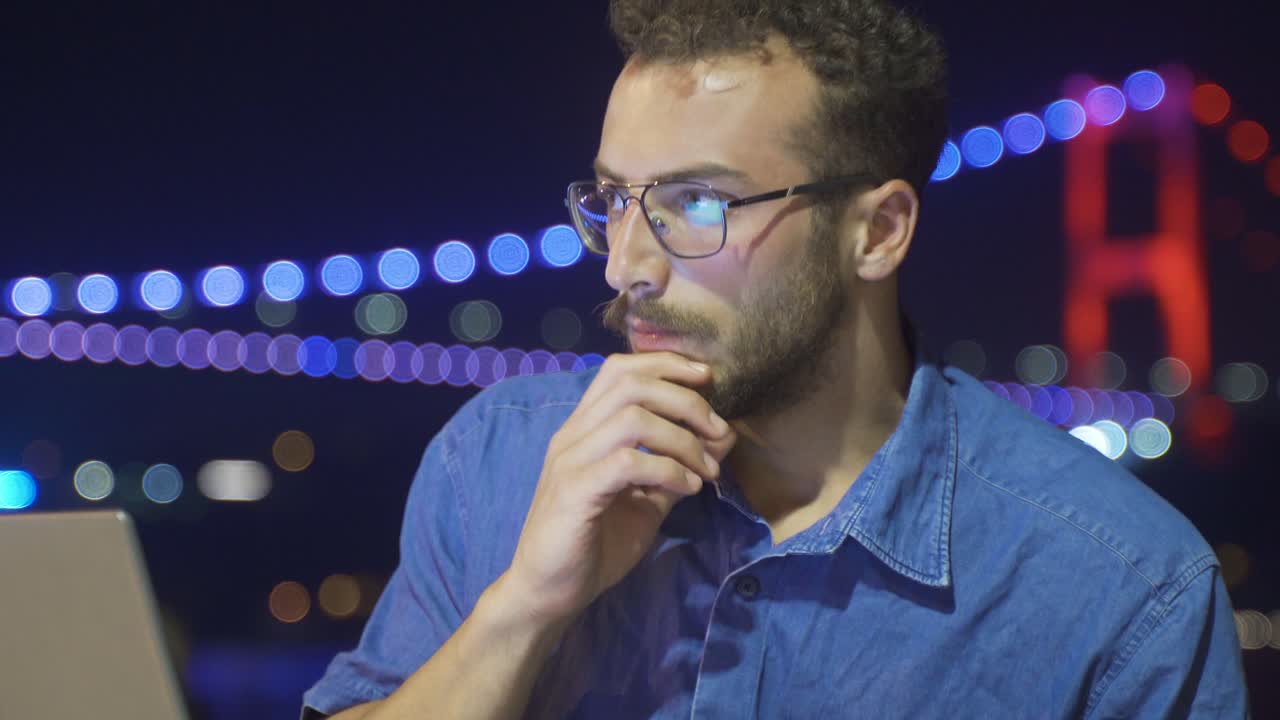 el uso nocturno de la computadora portátil al aire libre. pensativo y encuentra ideas.