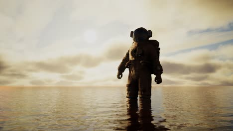 spaceman in the sea under clouds at sunset