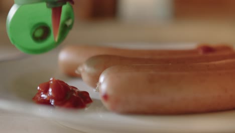 pouring ketchup on a plate with sausages