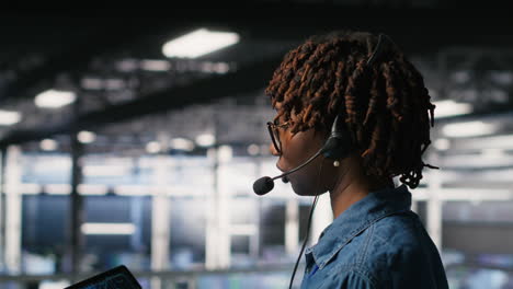 data center worker speaks in headset mic, overseeing maintenance on ai rigs