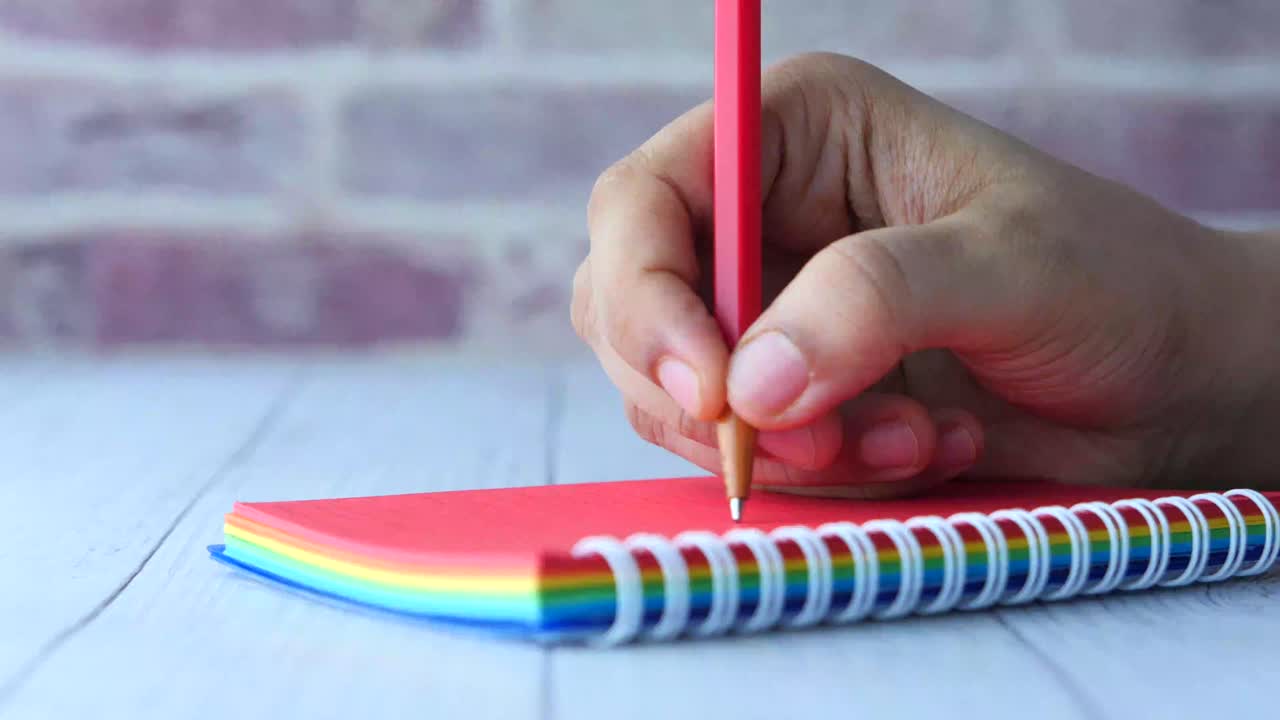 다채로운 나선형 노트북에 손으로 쓰는 것