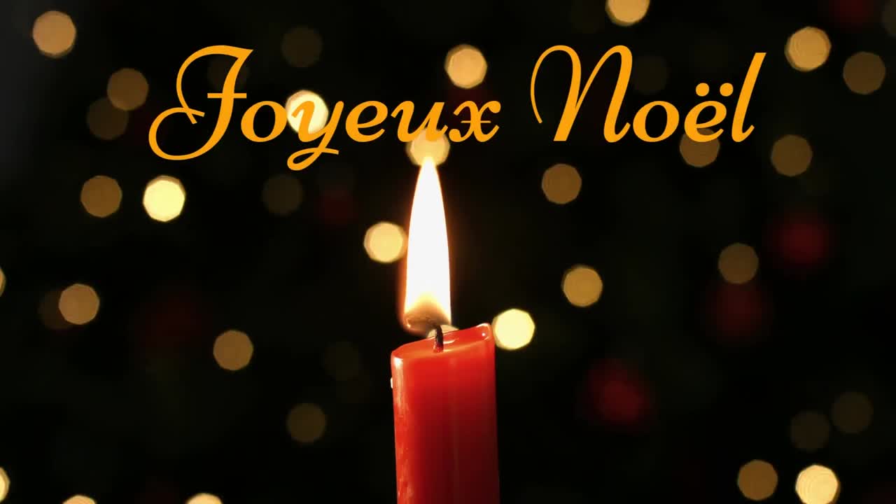 Joyeux No&Atilde;&laquo;l written over lit candle