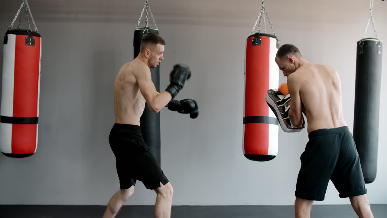 Men practicing Muay Thai in a gym
