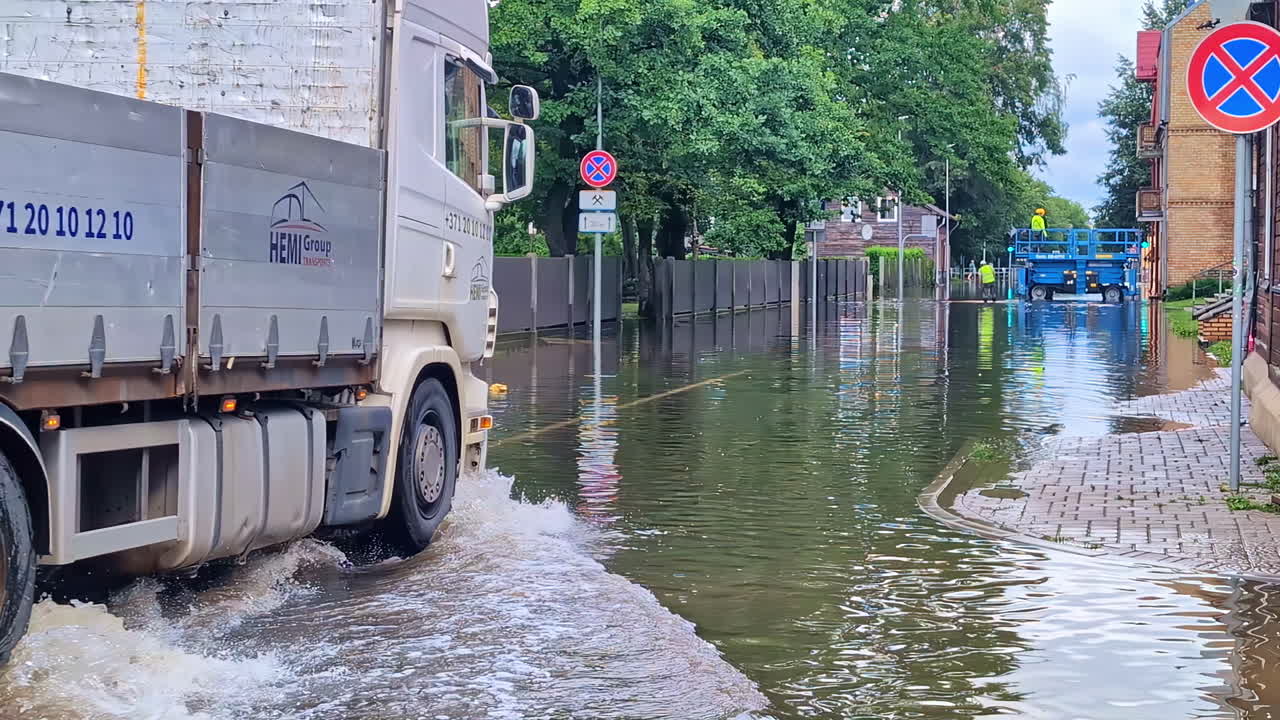 A Loader Truck is Passing Through a Flooded Road - Slow Motion