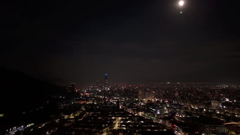 santiago, chile, zoom out timelapse view of cityscape showing modern buildings at night.