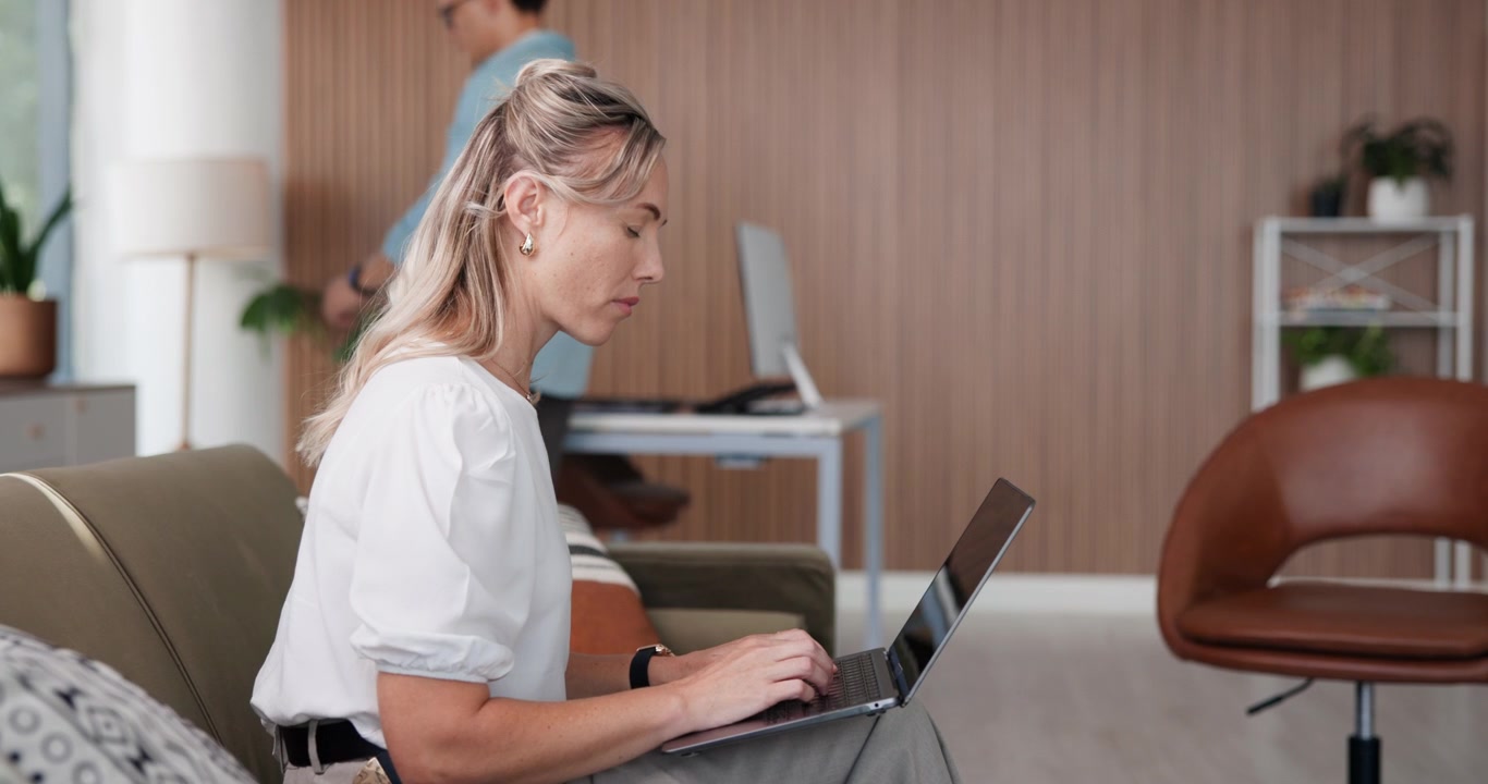Woman Working on Laptop on Sofa in Modern Office