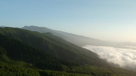 Aerial-view-of-a-mountain-side-with-a-sea-of-clouds-in-it,-on-an-island,-La-Palma,-Spain