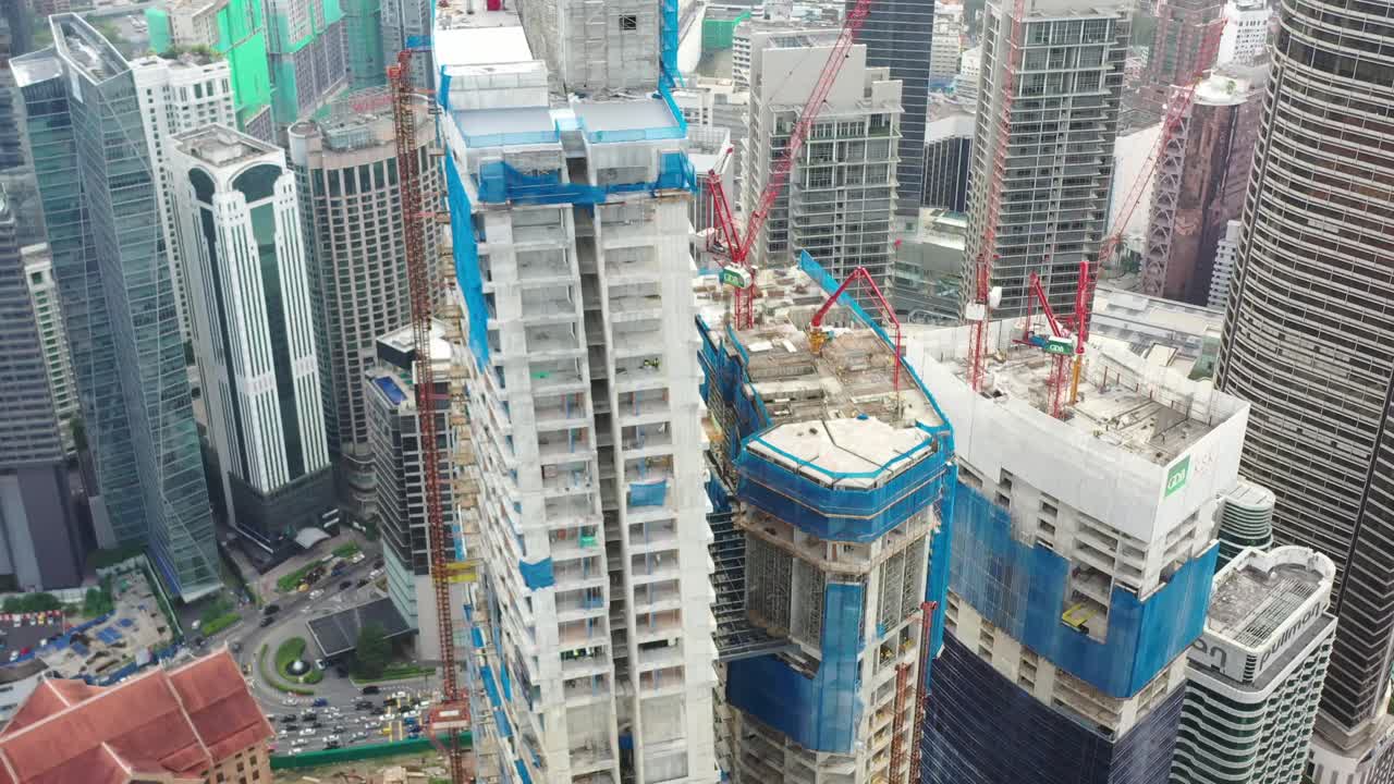 volar alrededor del edificio de gran altura imperial lexis en construcción rodeado por un paisaje urbano de alta densidad en el centro, desarrollo urbano en kuala lumpur, malasia, asia