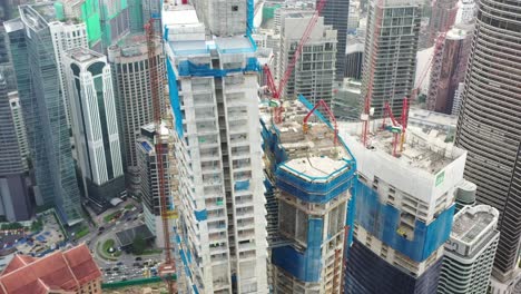 fly around imperial lexis high rise building under construction surrounded by high density downtown cityscape, urban development in kuala lumpur, malaysia, asia