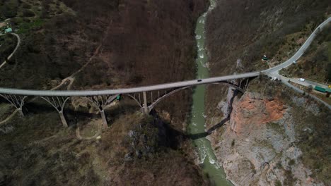 aerial view of the tara bridge in montenegro with passing cars, which is part of an important road between belgrade and podgorica