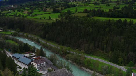 Aerial-Flying-Over-Castle-Bruck-Beside-River-Isel-In-Austria-With-Countryside-Landscape-In-Background