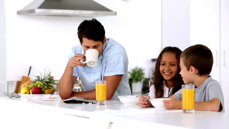 padre desayunando con sus hijos y bebiendo café