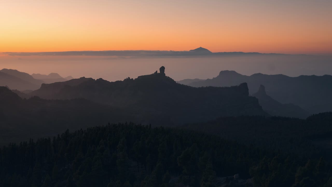 Breathtaking timelapse of Roque Nublo at sunset, with golden light over the mountains and Teide in the distance. A serene and cinematic scene, perfect for nature, travel, and adventure projects.