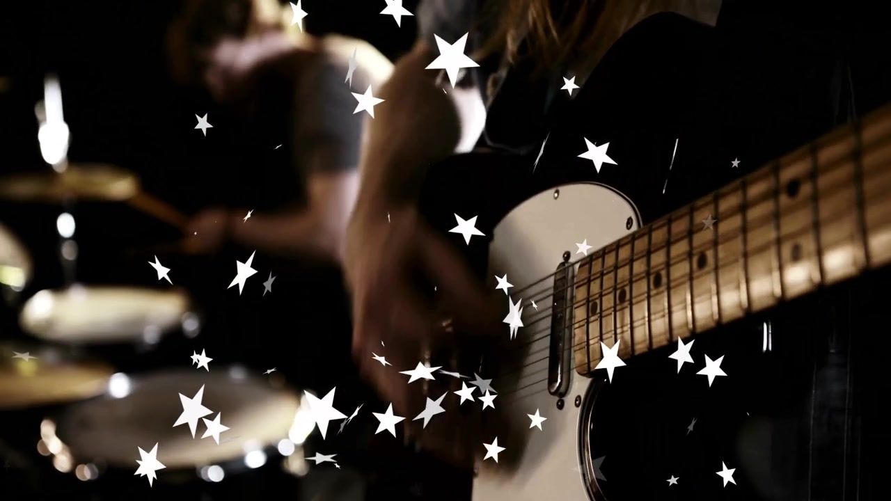 En guitarist spiller på en hvid guitar, der fremkalder stjerner, mens en trommeslager slår på trommer og skaber musikalsk energi.