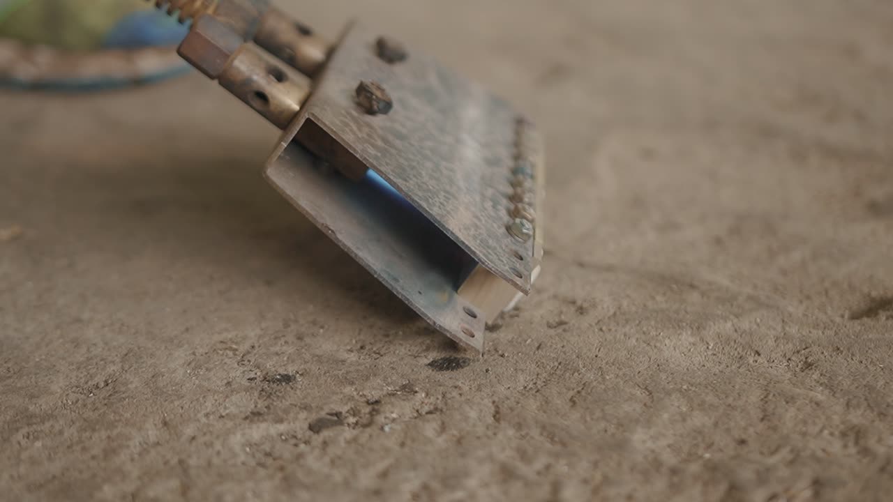 Metallic stamp tool in use on textured surface with lighting