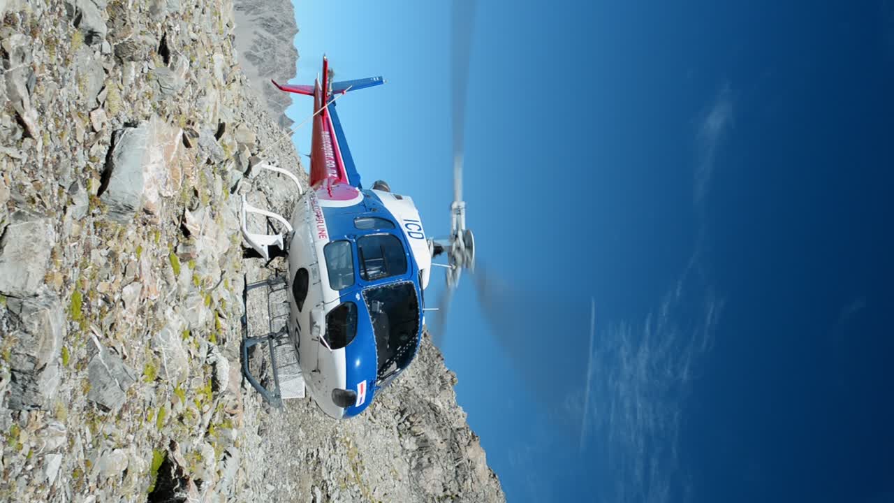 helicóptero con rotores giratorios en terreno rocoso y alpino