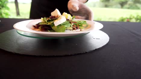 Die-Hände-Des-Küchenchefs-Legen-Beim-Wenden-Dressing-Auf-Den-Salat