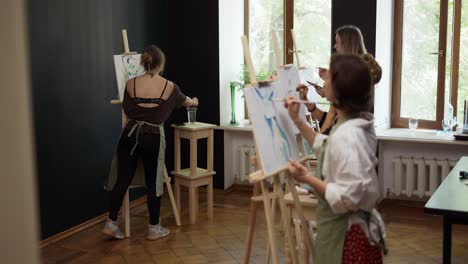 hermosas estudiantes pintando en la lección de arte en el estudio