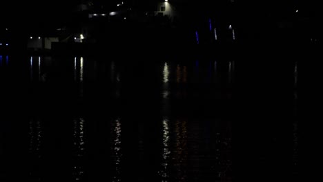 lights reflecting on the dark water of a lake at night, calm peaceful concept